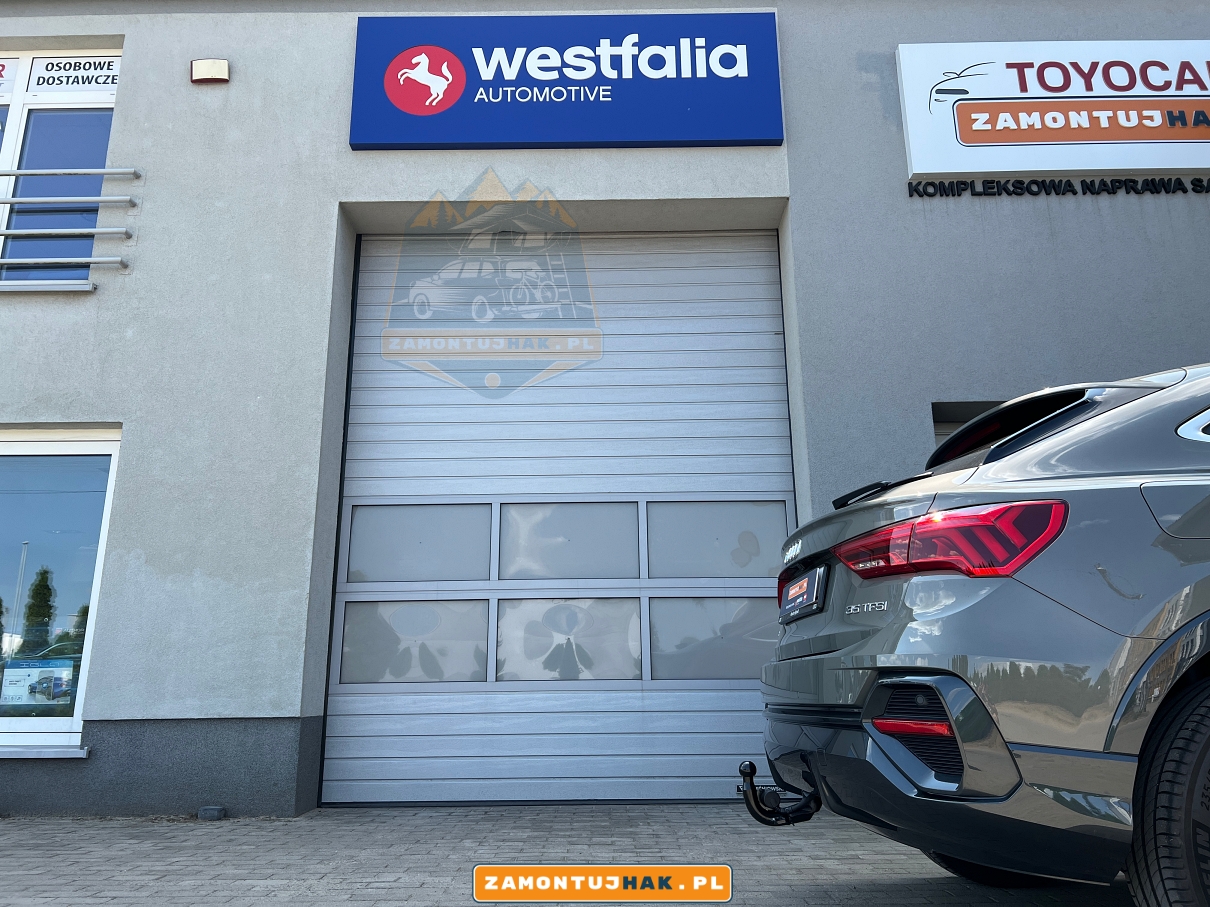 ZDJECIE SAMOCHODU AUDI Q3 F3N F3B OD BOKU Z TYLU POKAZUJE HAK HOLOWNICZY Z ZINTEGROWANYM GNIAZDEM 13PIN HAK ELEKTRYCZNY O NUMERACH 305587900113